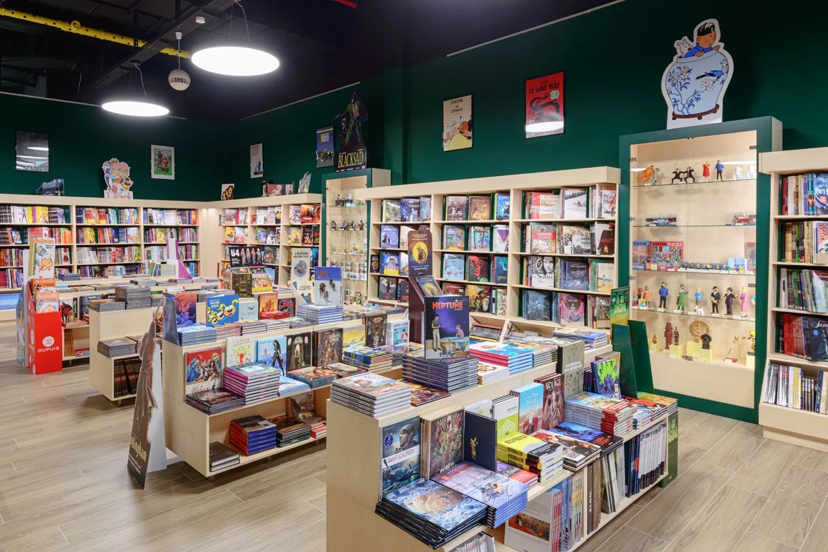 Intérieur lumineux d’une librairie Slumberland BD World, avec ses rayons de bandes dessinées